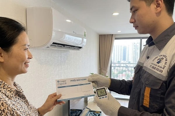 Kỹ thuật viên bàn giao máy đã sửa xong cho khách tại căn hộ Hà Nội